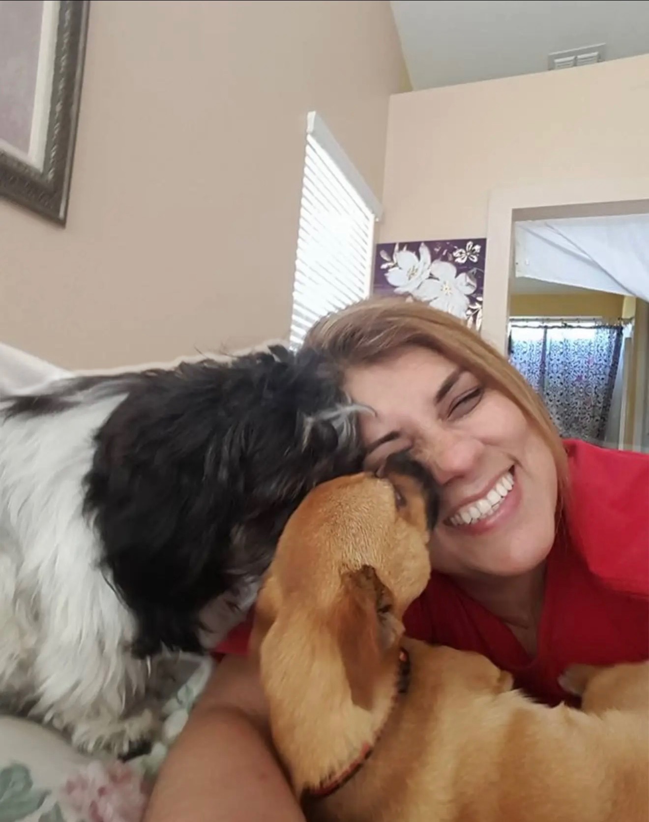 Marlene Sarria smiling with two beloved dogs